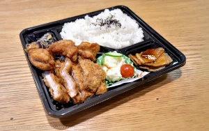 木製のテーブルの上に　お弁当　が　のっている写真です